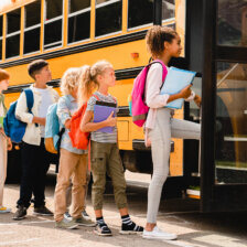 School children lined up to enter a school bus