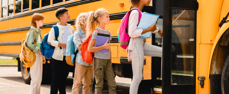 School children lined up to enter a school bus